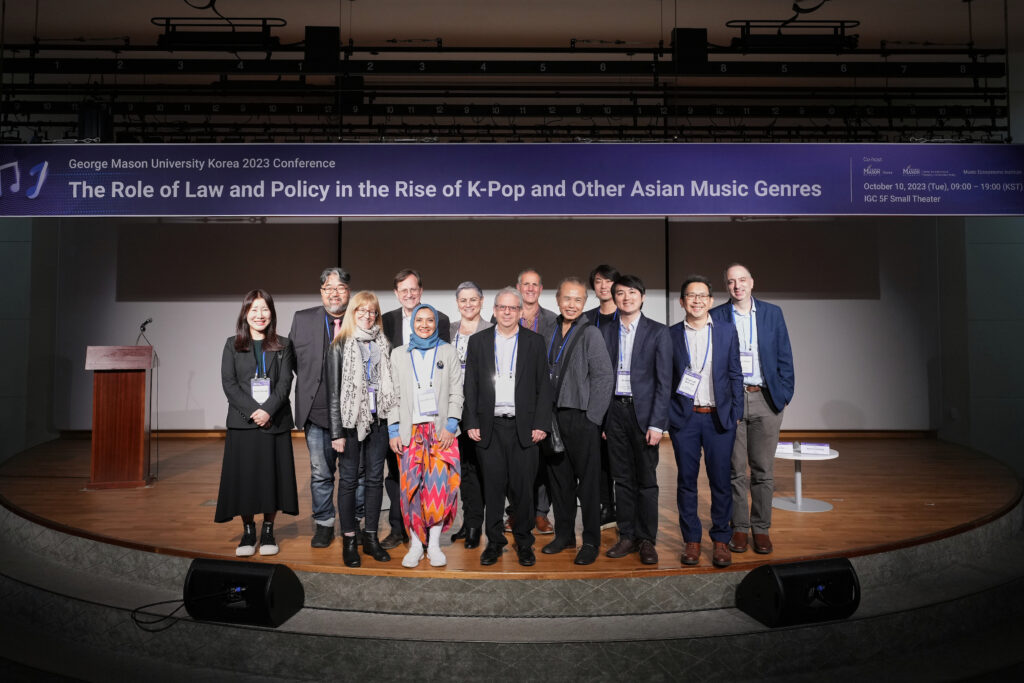 Speakers pose for an on-stage photo at the October 10, 2023, conference on music and law at Mason Korea